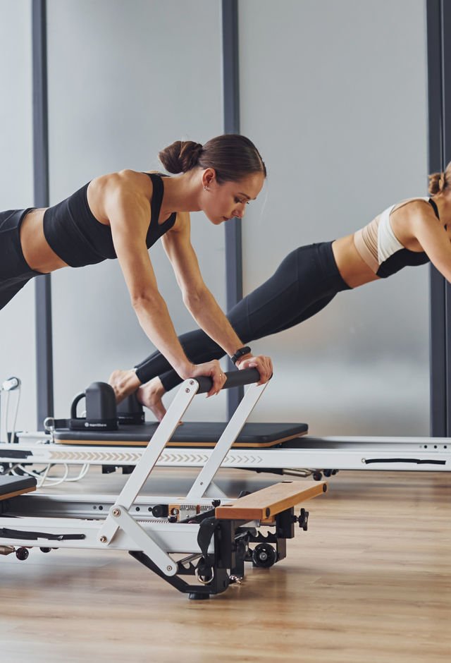 Two women practicing mat Pilates